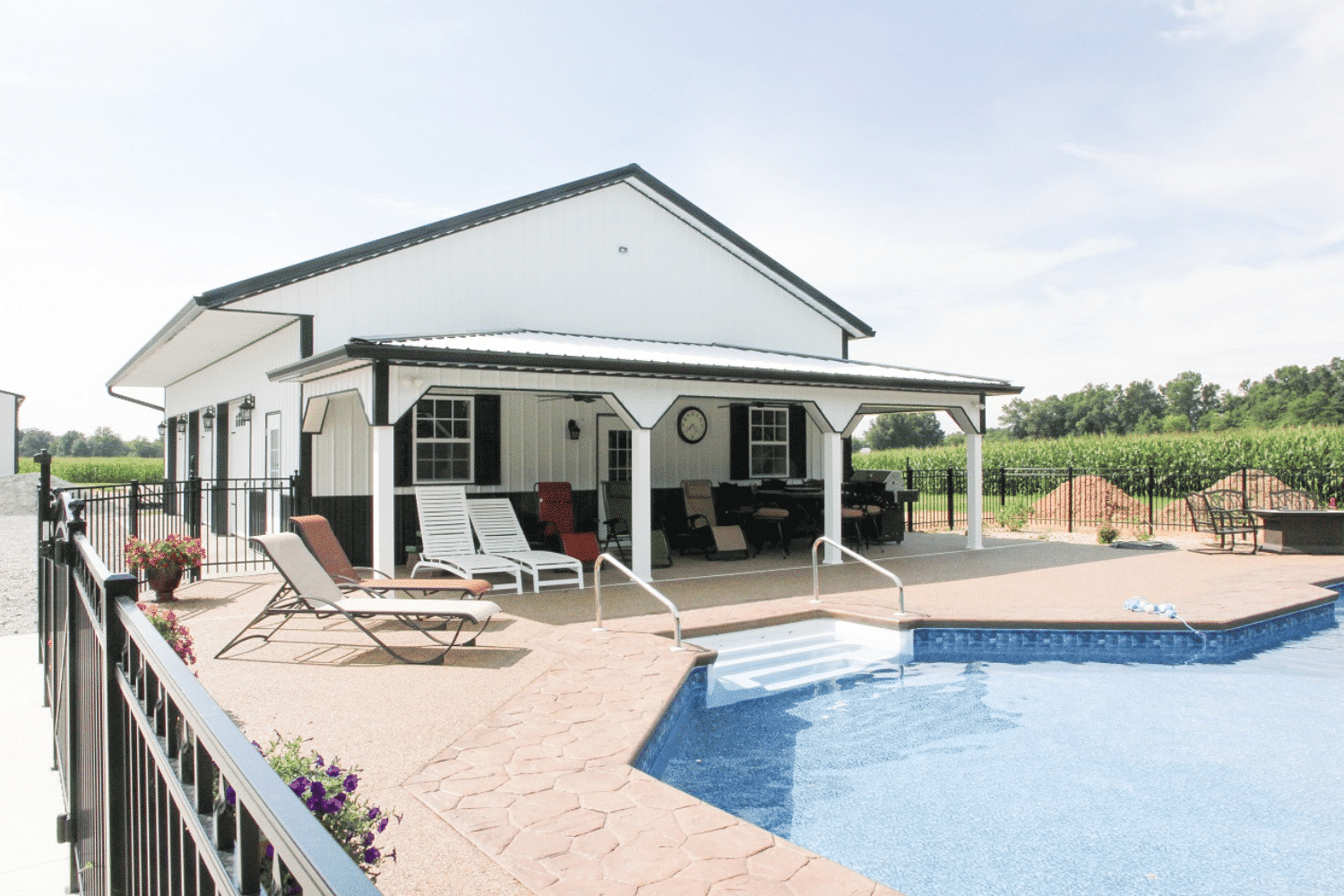 a white 20x48 barndominium standing outside by a pool