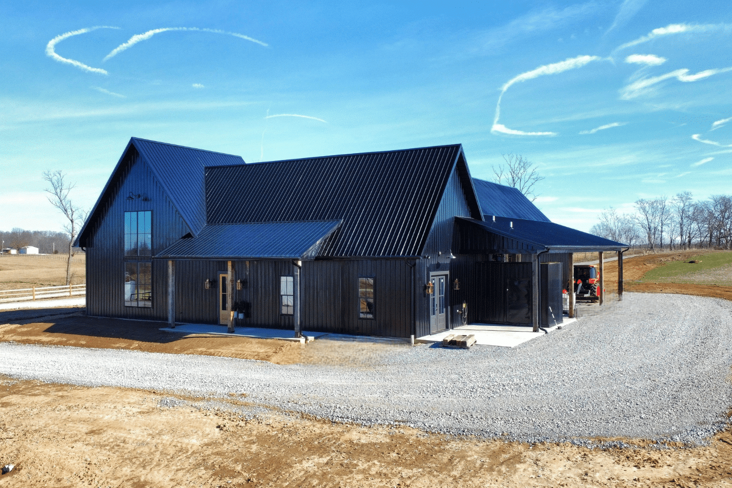 black 24x24 barndominium with tall windows and porches