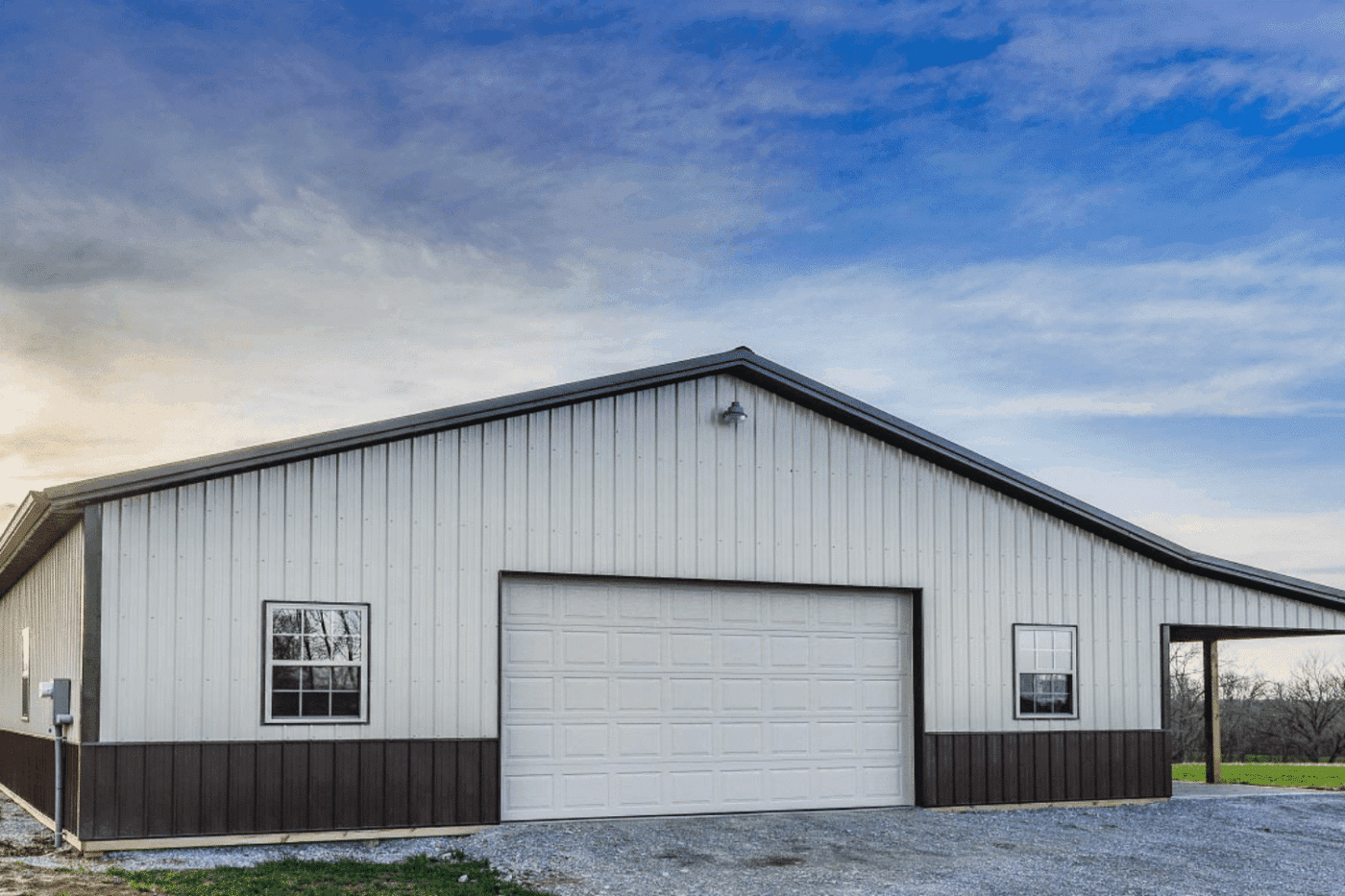 a 25x50 commercial pole barn with a wide white garage door