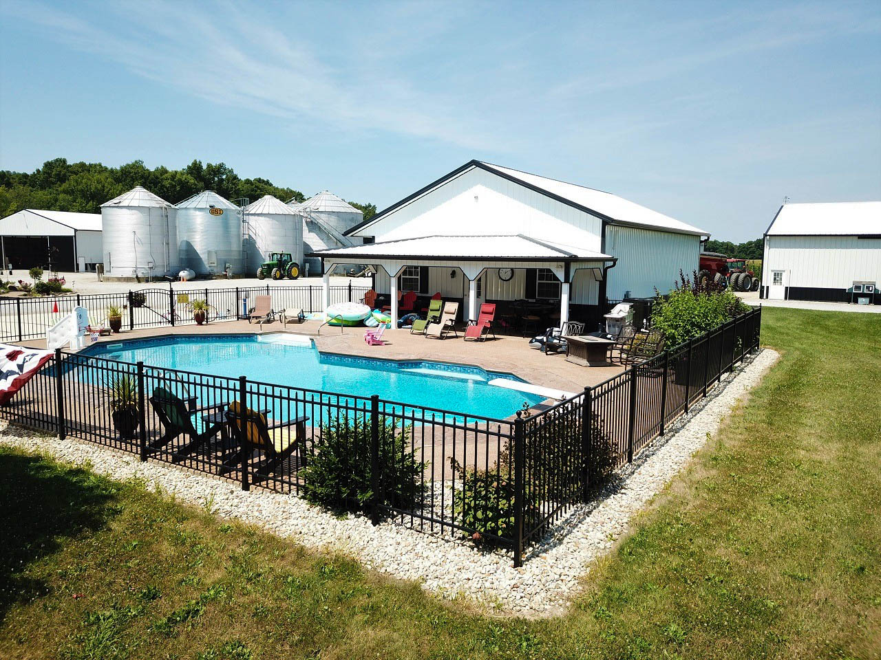 white and black 48x80 Pole Barn Garage Kits by a pool
