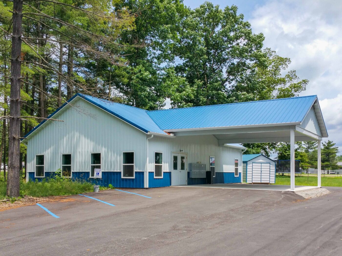 a white 25x50 commercial pole barn with a blue roof
