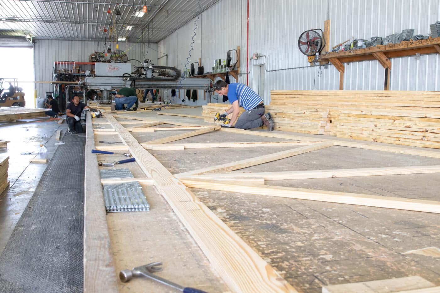 men putting together roof trusses for a 20x30 pole barn garage