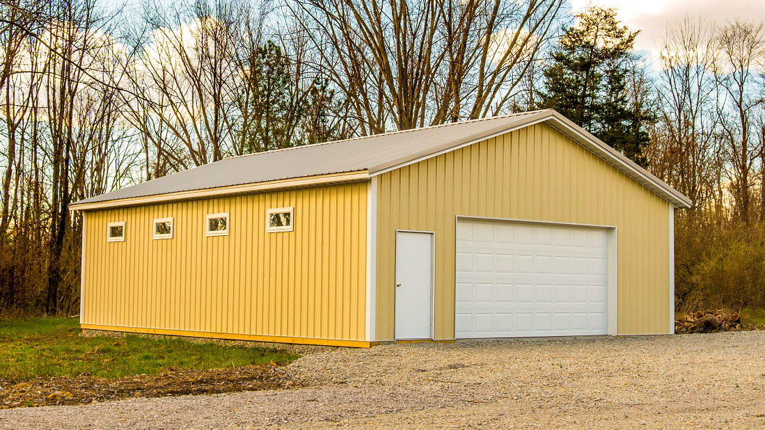 yellow pole barn garage with a bright roof
