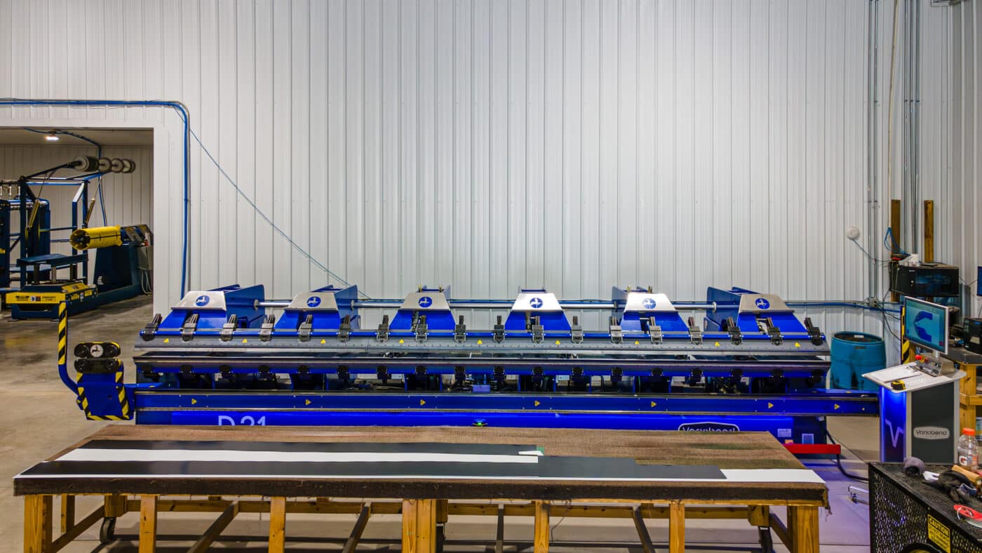 blue machine used to cut metal panels to custom specifications for pole barn garage kits