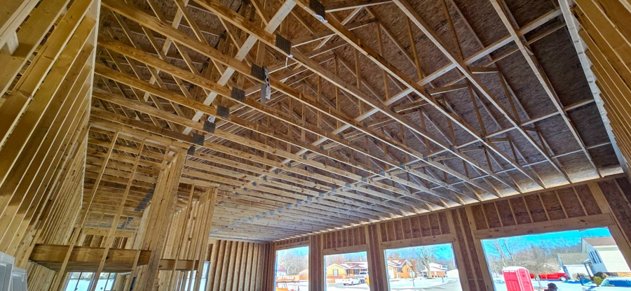 closer up shot of roof trusses in the garage portion of this home