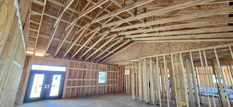 inside of home with roof trusses and double doors