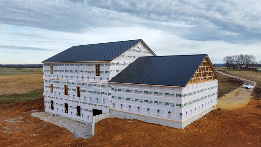 multi-story home wrapped featuring black metal roofing panels