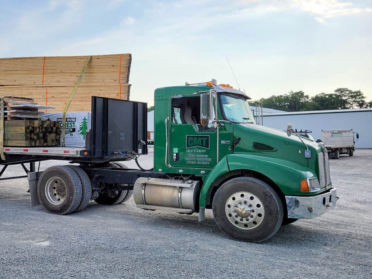 roof trusses getting ready to be delivered on the back of a green truck