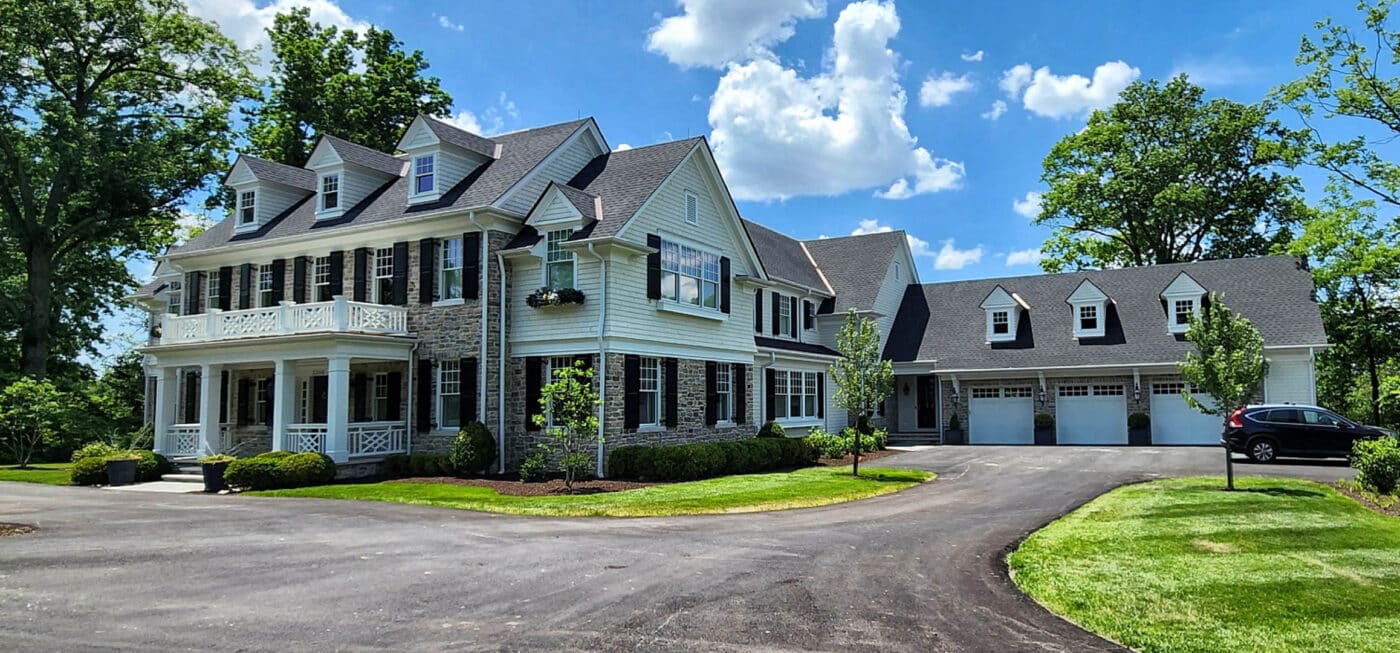 A stone 75x100 barndominium with white siding and a grey shingle roof