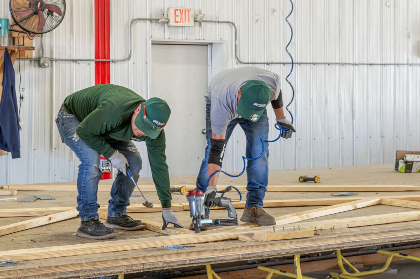 two men working together to put together roof trusses for a 24x24 barndominium