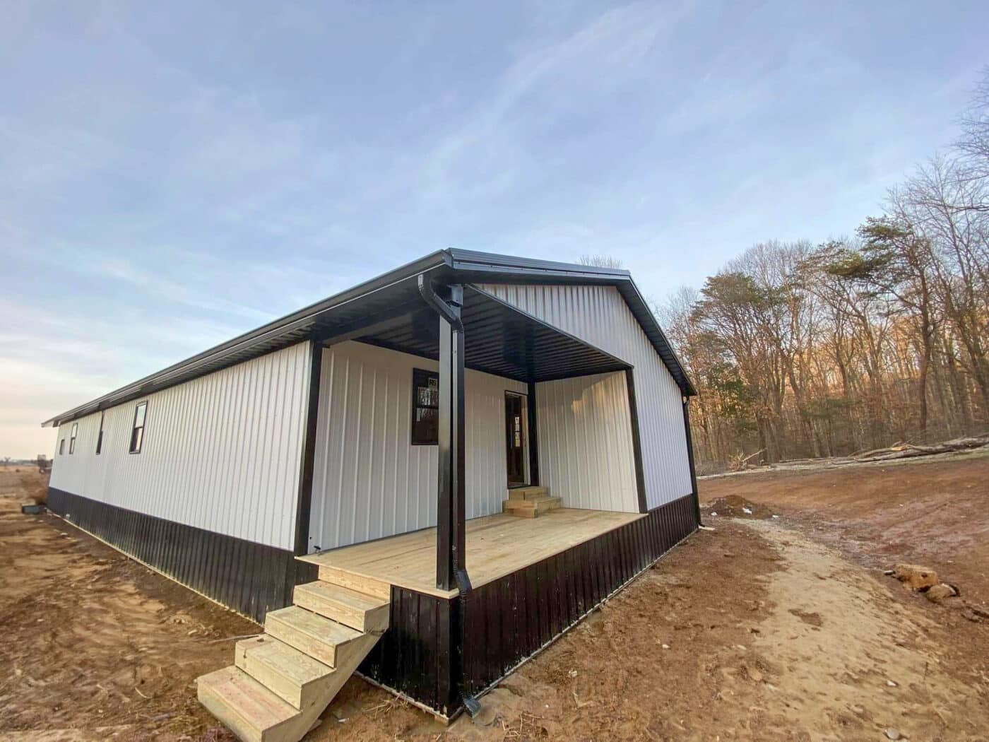 white and black trimmed barndominium with side porch