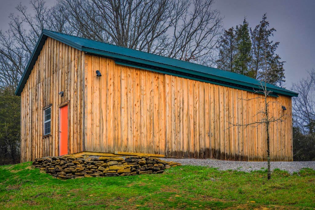 wooden 42x64 agricultural pole barn with a green roof